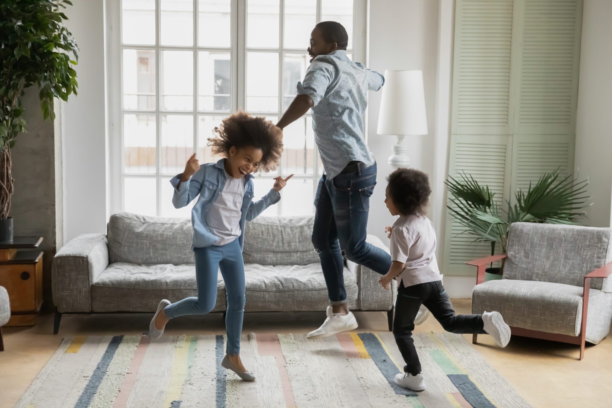 Family dancing joyfully in living room.