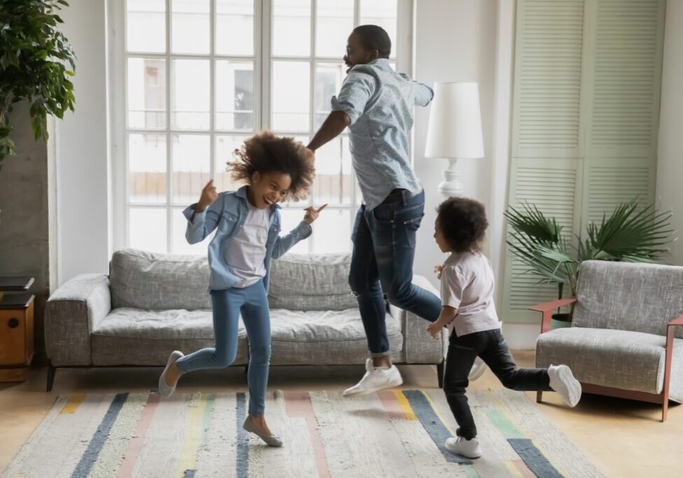 Family dancing joyfully in living room.